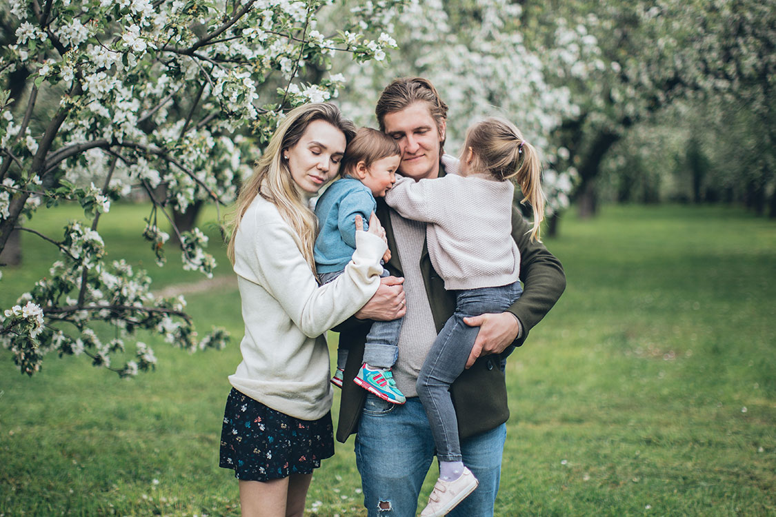 Junge Familie mit 2 Kindern auf dem Arm