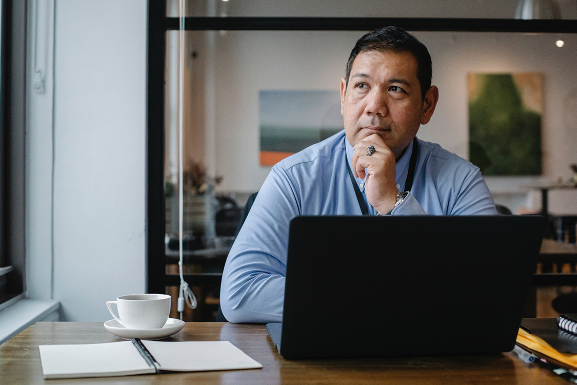 Unternehmer sitzt am Laptop und denkt über sein Unternehmenstestament nach