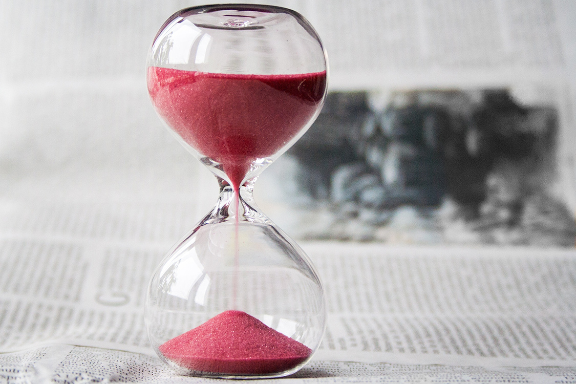Sanduhr steht auf einer Zeitung