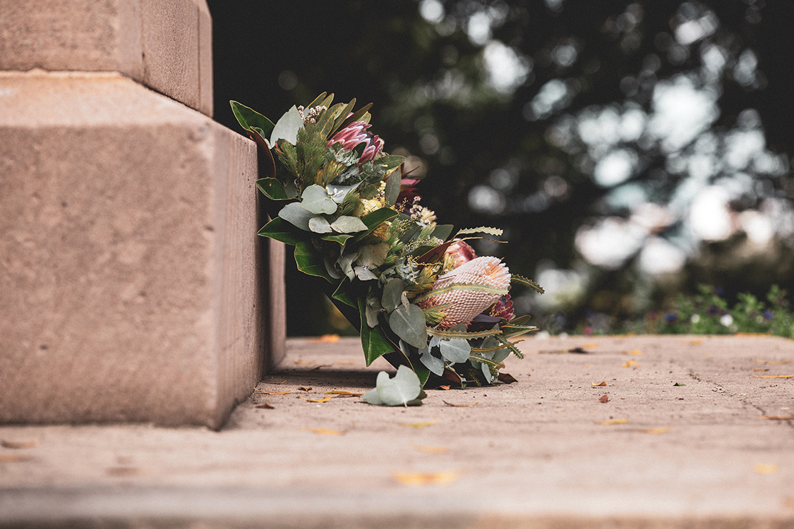Blumenkranz vor einem Grabstein